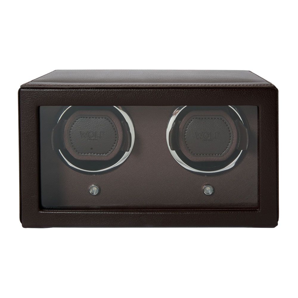 The WOLF 1834 Cub Double Winder with Cover in Brown by WOLF is a rectangular watch winder elegantly crafted from vegan leather, featuring a glass front that displays two circular slots for holding watches, offering a stylish and sustainable display.