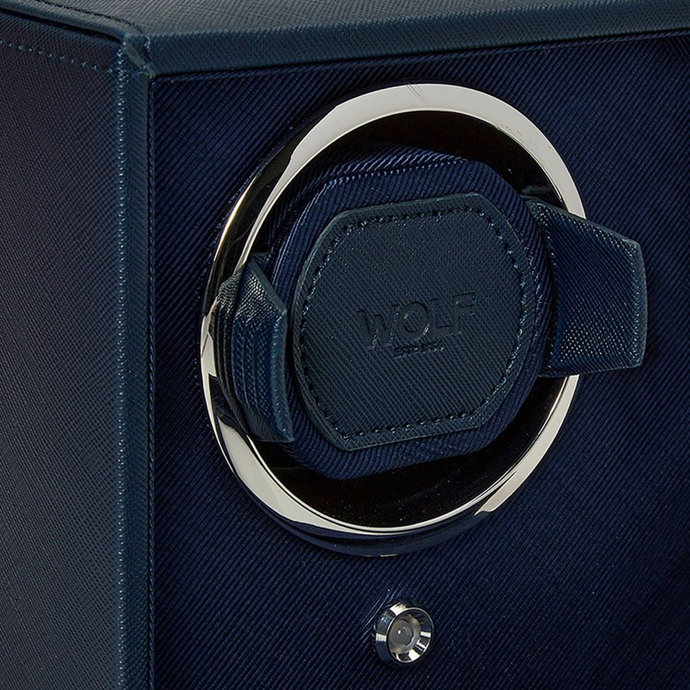 Close-up of the WOLF 1834 Cub Double Winder With Cover in Navy, featuring a circular metallic frame, a vegan leather strap marked “WOLF,” and a small control knob beneath.