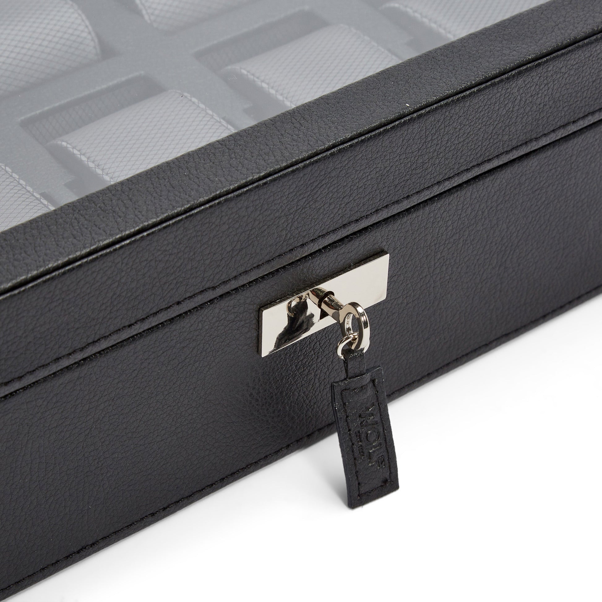 Introducing the WOLF 1834 10 Piece Watch Box: a sleek black storage solution crafted from vegan leather. It boasts a transparent lid that reveals multiple compartments inside. The box is secured with a metallic lock and key on the front, proudly emblazoned with the "WOLF" brand name.