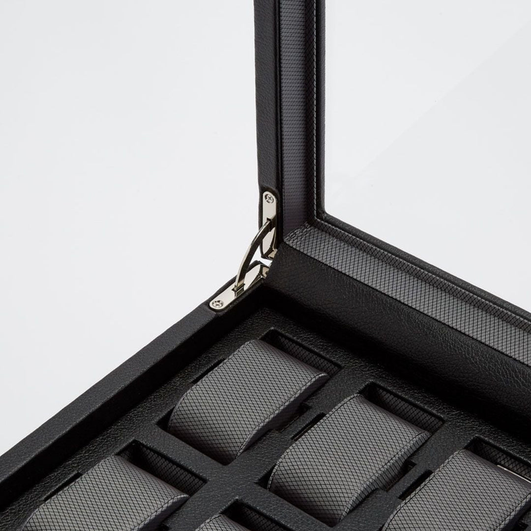 Close-up of an open WOLF 1834 Viceroy 10 Piece Watch Box with Drawer, featuring a sleek vegan leather design and a glass lid. Inside, multiple grey fabric watch cushions are neatly arranged for display, highlighting the box's craftsmanship. Its open metal hinge is visible.