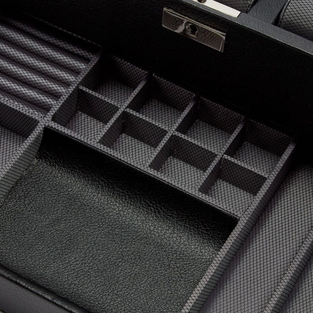 A detailed view of the empty WOLF 1834 Viceroy 10 Piece Watch Box with Drawer, crafted from black vegan leather, reveals multiple compartments in various sizes. The watch storage section is equipped with a lock, and the interior boasts a textured pattern ideal for securing small items.