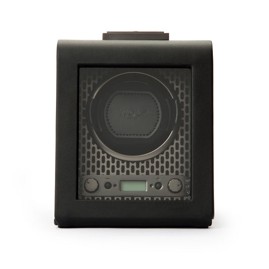 The WOLF 1834 Axis Single Watch Winder features a stylish black design with a glass front that beautifully reveals its internal mechanism. Its design is equipped with a digital display and control buttons, offering versatile rotation options. The textured background enhances its sophisticated appearance, while the secure lock-in dynamic cuff provides added security.