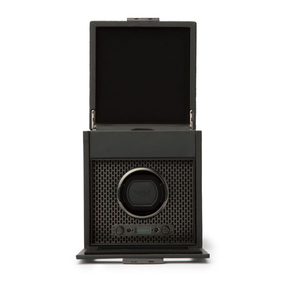 The WOLF 1834 Axis Single Watch Winder With Storage is an open black winder box that features a hexagonal pattern interior, rotation options, and a lock-in dynamic cuff to automatically wind watches.