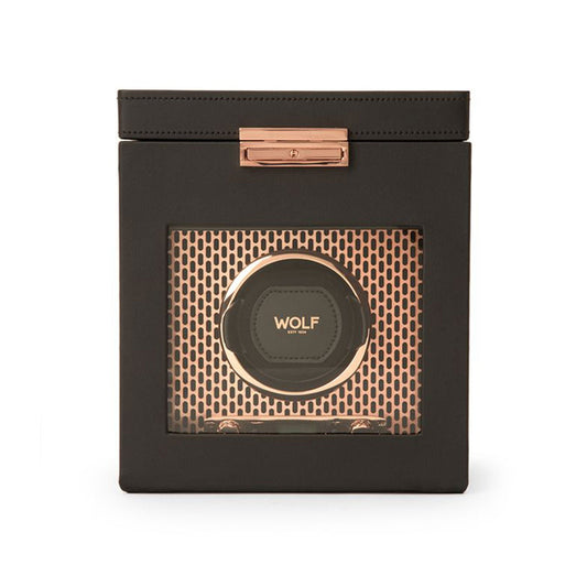 The WOLF 1834 Axis Watch Winder is a sleek black and gold device with a transparent front that proudly displays the "WOLF" brand inside. This elegant timepiece storage solution includes rose gold accents and a grid pattern background, providing various rotation options to ensure your watches remain in perfect condition.