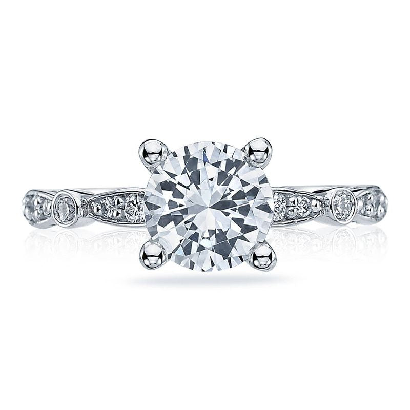 The Tacori Sculpted Crescent 18K White Gold Round Brilliant Solitaire Semi Mount Engagement Ring showcases a large, round diamond at its center. Its band is embellished with bezel-set diamonds, enhancing the ring's elegant design and sparkle, which highlights the exceptional craftsmanship of Tacori gemologists.