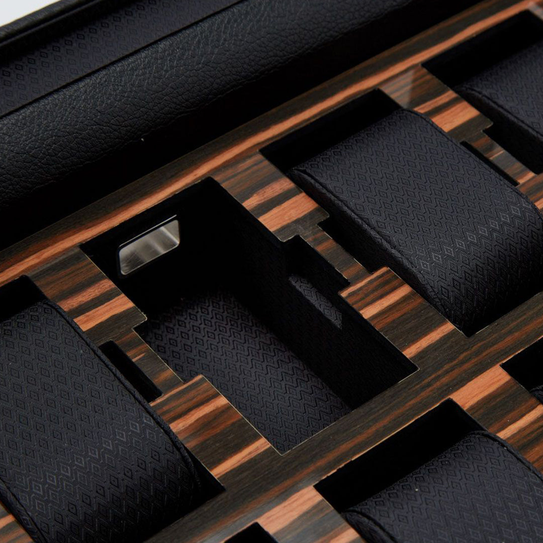 A close-up of the WOLF 1834 Roadster 10 Piece Watch Box, featuring an elegant black and wood design. Multiple padded compartments for storing watches are lined with textured vegan leather, offering a sophisticated contrast to the rich wood finish.