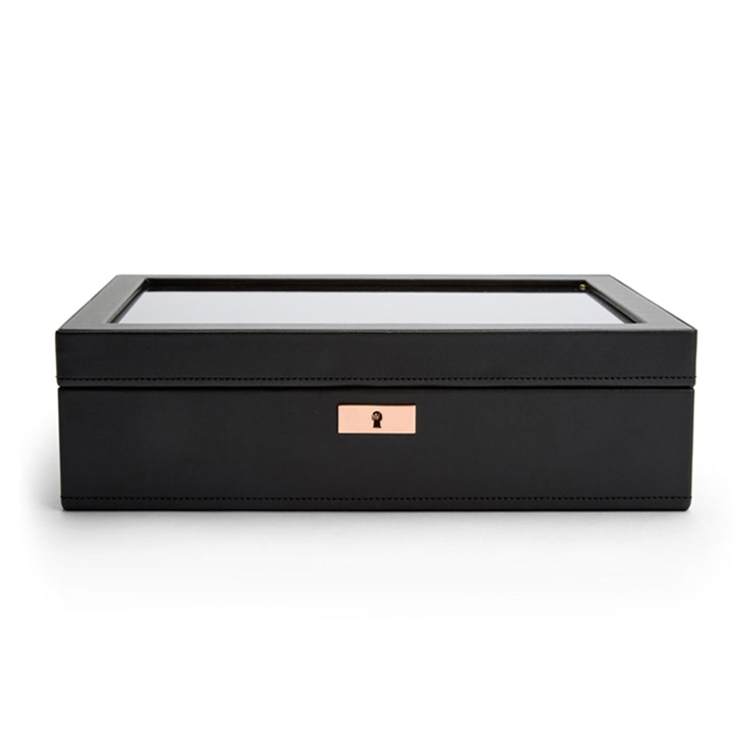 The WOLF 1834 Axis 10 Piece Watch Box by WOLF is a sleek, rectangular black jewelry box designed with lock and key security. It features a transparent glass lid and a subtle golden lock on the front. Inside, suspended watch cushions offer impeccable storage for watches.