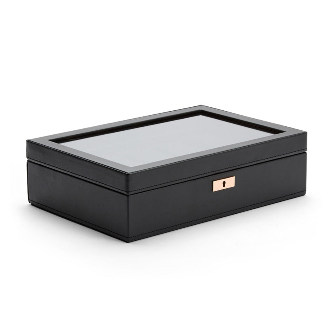 The WOLF 1834 Axis 10 Piece Watch Box by WOLF is a sleek black rectangular storage solution featuring suspended watch cushions, a transparent glass lid, and a small keyhole in the front for lock and key security.