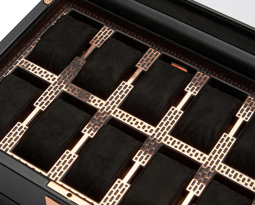 The WOLF 1834 Axis 10 Piece Watch Box, by the renowned brand WOLF, is a luxurious black storage box featuring a glass lid that reveals an array of gold-toned compartments. Each compartment houses suspended watch cushions designed to hold watches securely. The lock and key security feature adds to the box's elegant design, showcasing its sophisticated craftsmanship.