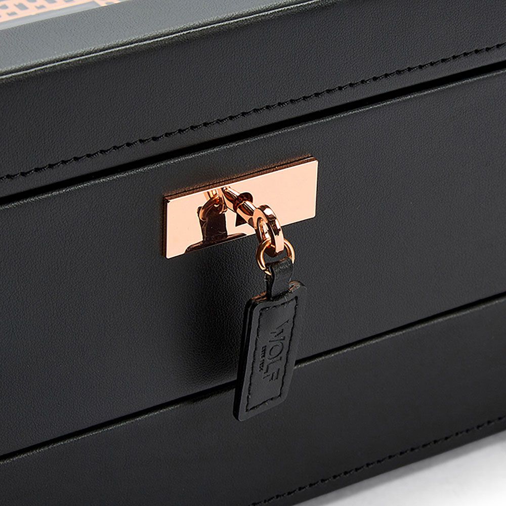 A close-up of the gold lock on the WOLF 1834 Axis 10 Piece Watch Box With Drawer showcases the elegant security system, featuring a key with a black leather tag labeled “WOLF” attached. This refined lock and key mechanism ensures your treasured timepieces by WOLF remain safely secured.