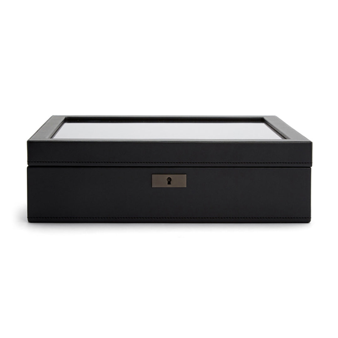 The image is centered on the WOLF 1834 Axis 15 Piece Watch Box, a sleek and elegant black storage box with a glass top. It includes a small keyhole on the front, offering lock and key security for added safety and embodying a minimalist design.