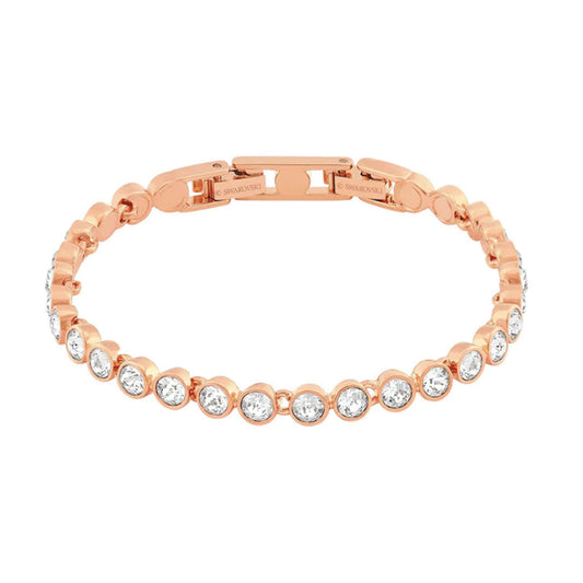 The Swarovski Tennis Bracelet by Swarovski features a rose gold design embellished with shimmering, clear crystals evenly distributed along the band. Its visible clasp highlights an elegant and simplistic style that embodies sophisticated jewelry.
