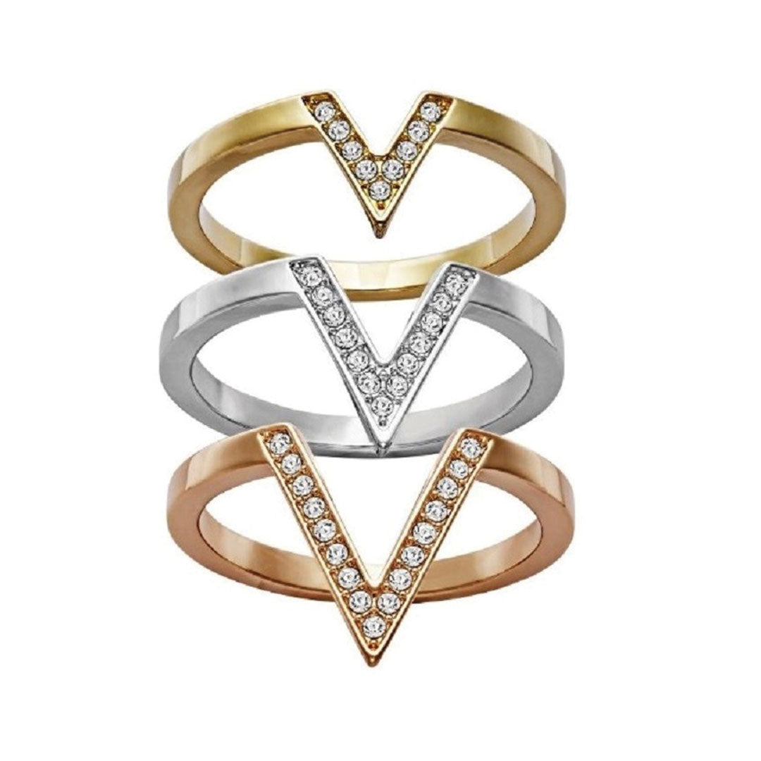 The Swarovski Delta Tri-Colour Three Rings Set by Swarovski features a trio of elegant V-shaped rings arranged vertically, with a gold ring at the top, a silver ring in the middle, and a rose gold ring at the bottom. Each piece is adorned with small Swarovski crystals along the V-shape, radiating modern sophistication and sparkle.