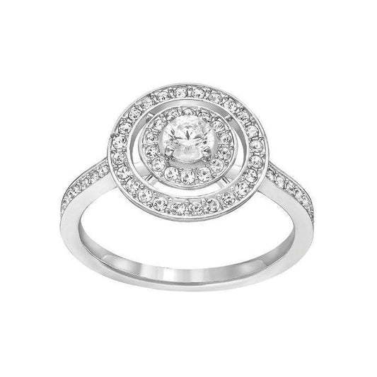 The Swarovski Attract Ring showcases a sleek silver band adorned with a prominent central diamond, encircled by two rings of smaller, shimmering Swarovski crystals. The band glows with intricate and elegant detailing that beautifully captures and reflects light.