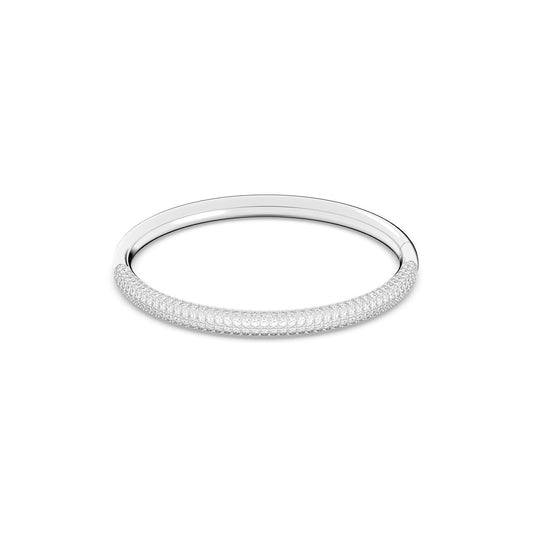 The Swarovski Stone Bangle, by renowned brand Swarovski, is a silver accessory adorned with sparkling clear crystal pavé embellishments on its outer surface. This circular and elegantly designed piece elegantly showcases shimmering stones in a symmetrical pattern. Displayed on a plain white background, it features an integrated closure for seamless wear.