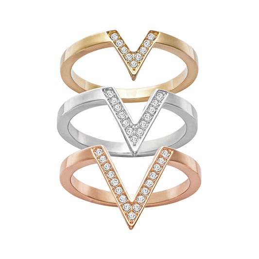 The Swarovski Delta Tri-Colour Three Rings Set from Swarovski features three vertically stacked V-shaped rings in a contemporary design. The elegant arrangement includes a gold ring on top, a silver one in the middle, and a rose gold ring at the bottom, each adorned with small, sparkling Swarovski crystals along their V shapes.