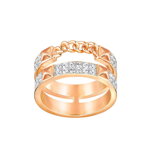 The Swarovski Fiction Ring, crafted by Swarovski, is a luxurious gold accessory featuring two connected bands linked by delicate chain links. Adorned with sparkling crystals and pyramid-shaped studs, the rhodium-plated bands are further enhanced with small diamonds for a stylish finish.