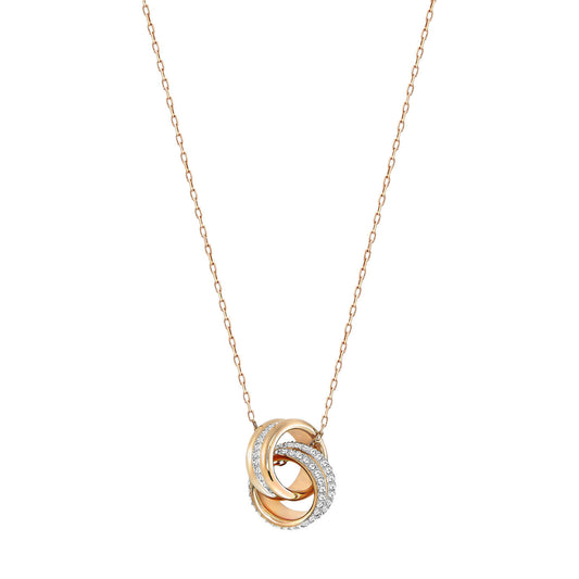 The Swarovski Rose Gold Further Necklace Pendant by Swarovski features a delicate gold chain with a pendant of interlocking rings. One ring is crafted in gold, another in silver, while the third sparkles with crystal pavé stones. Subtle rose gold plating enhances its elegant design, adding sophistication and charm.