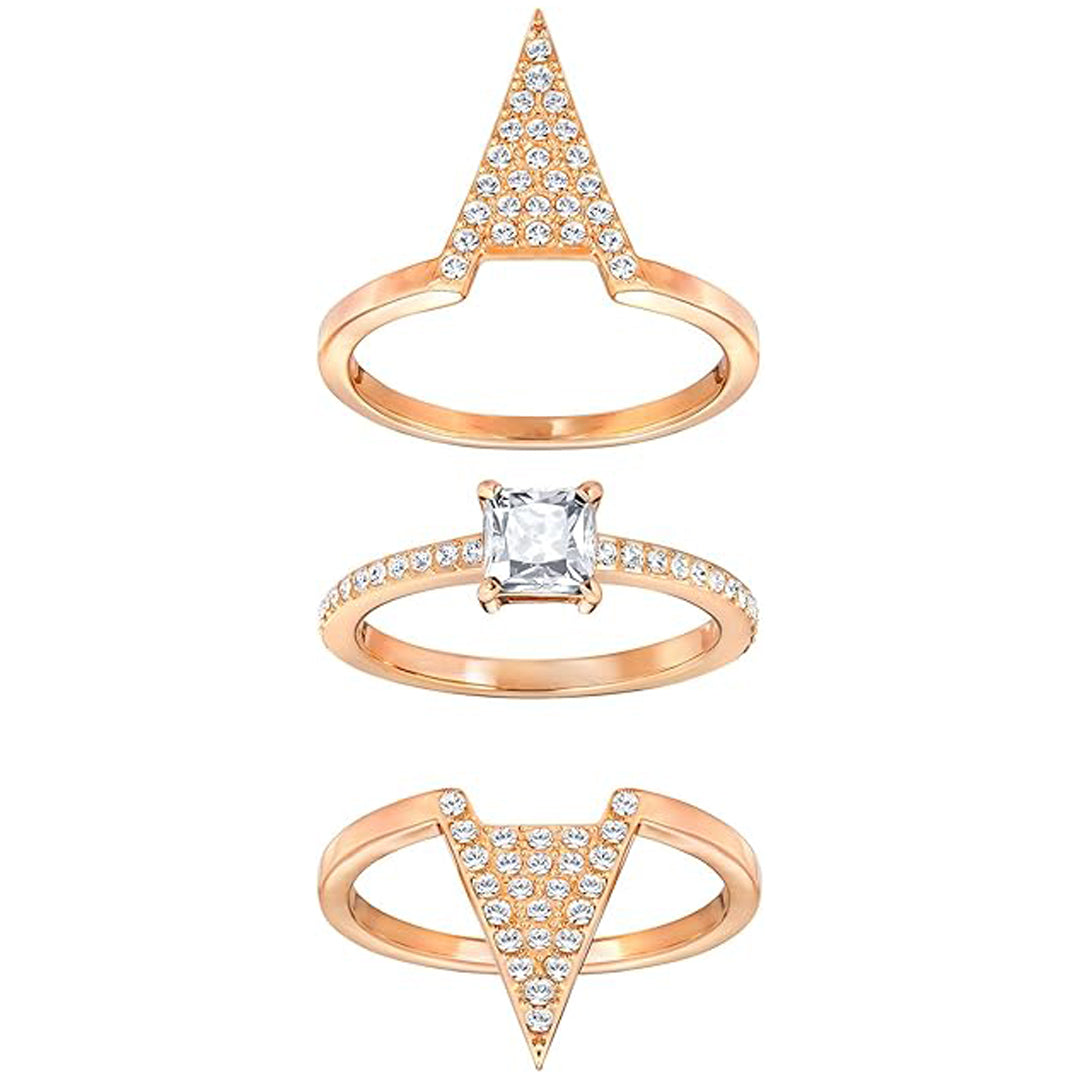 The Swarovski Funk Three Rings Set by Swarovski is displayed, featuring three gold rings. The top ring boasts a stunning triangular design embellished with small Swarovski crystals. The middle ring highlights a square-cut central crystal and comes with a rhodium-plated band, while the bottom ring displays an inverted triangle accented with crystals.