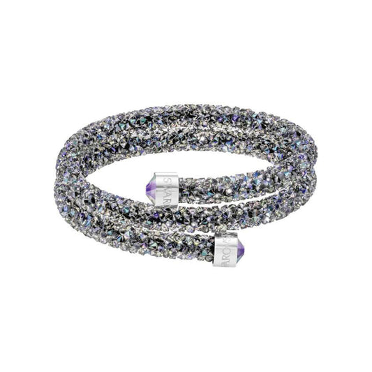 Introducing the Swarovski Crystal Dust Cuff, a dazzling and adaptable bracelet adorned with glimmering black and purple crystals. This piece is enhanced by two cylindrical end caps engraved with text, exuding a sense of luxury and elegance.