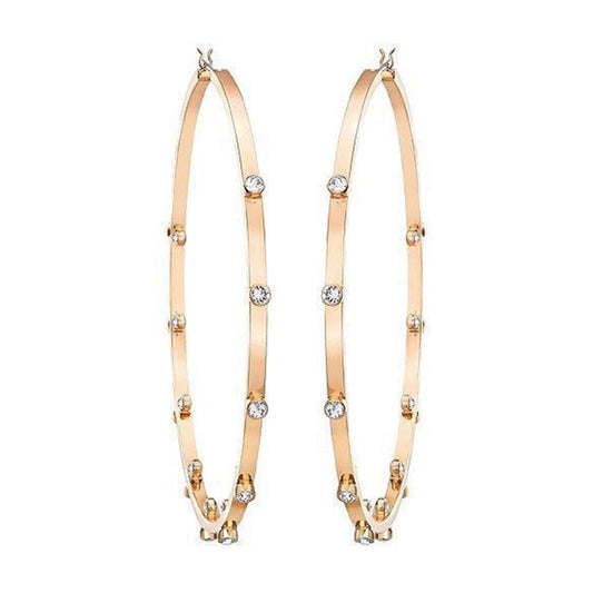 Swarovski's Genna Hoop Earrings, featuring gold hoops adorned with small, evenly spaced crystals, set against a white background.