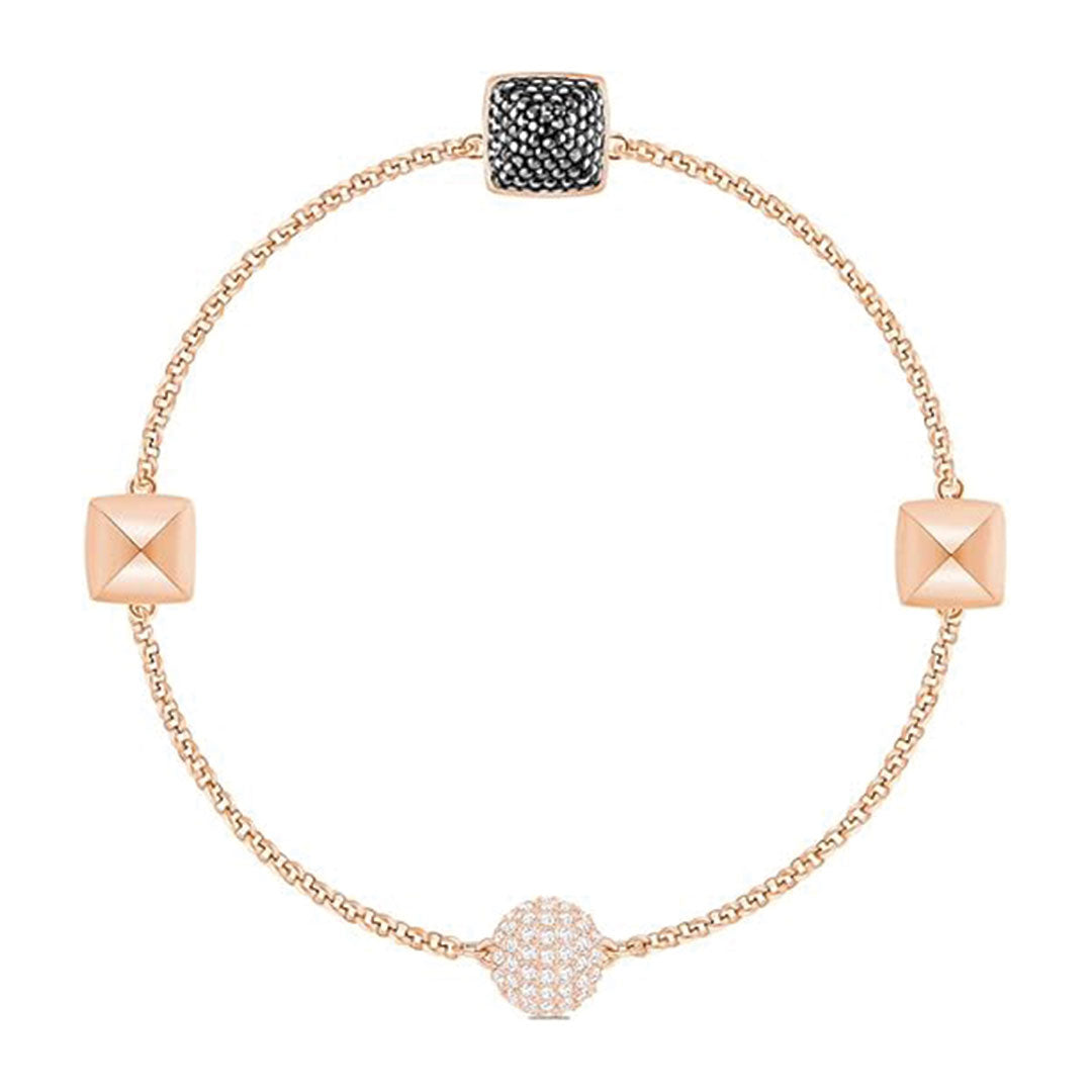 A finely crafted piece from the Swarovski Remix Collection Bracelet, this exquisite gold bracelet by Swarovski features three geometric charms: a circular charm encrusted with small white stones, a square charm adorned with black crystals, and a plain gold pyramid shape. It is elegantly designed with a thin, simple chain and rose gold plating.