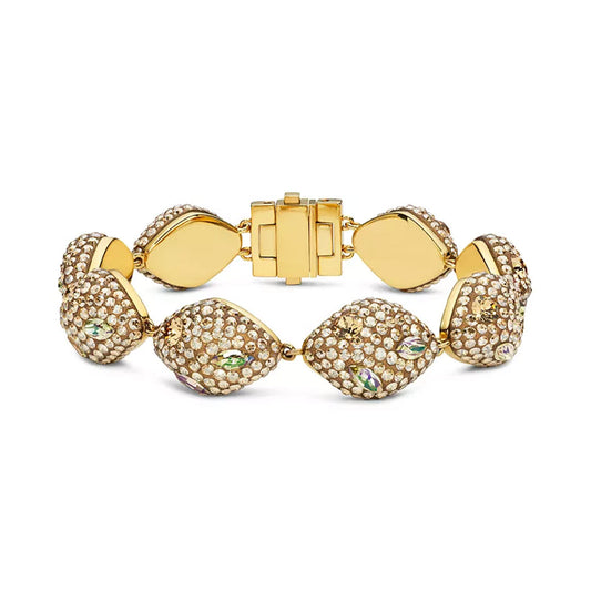 The Swarovski Atelier Moselle Bracelet, crafted by Swarovski, showcases a gold-tone plated design with textured oval beads adorned in Swarovski crystals. Featuring a gold hinge clasp, this bracelet offers an elegant and intricate aesthetic.