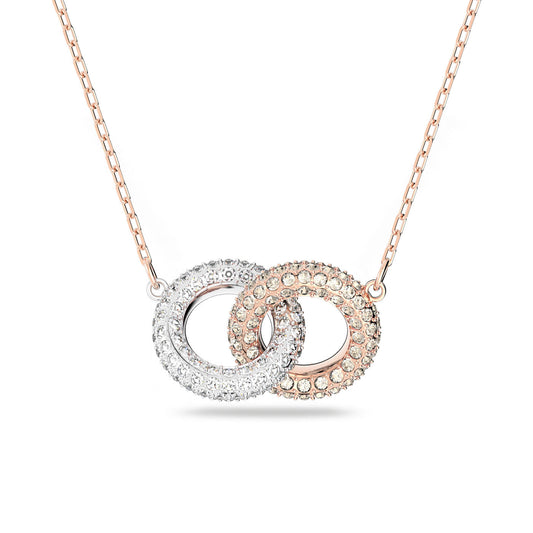 The Swarovski Intertwined Circles Necklace by Swarovski features a delicate chain that highlights two interlocking rings. One ring is crafted from silver and adorned with clear crystals, while the other boasts a rose gold-plated finish with matching crystals, forming a sparkling and elegant design.
