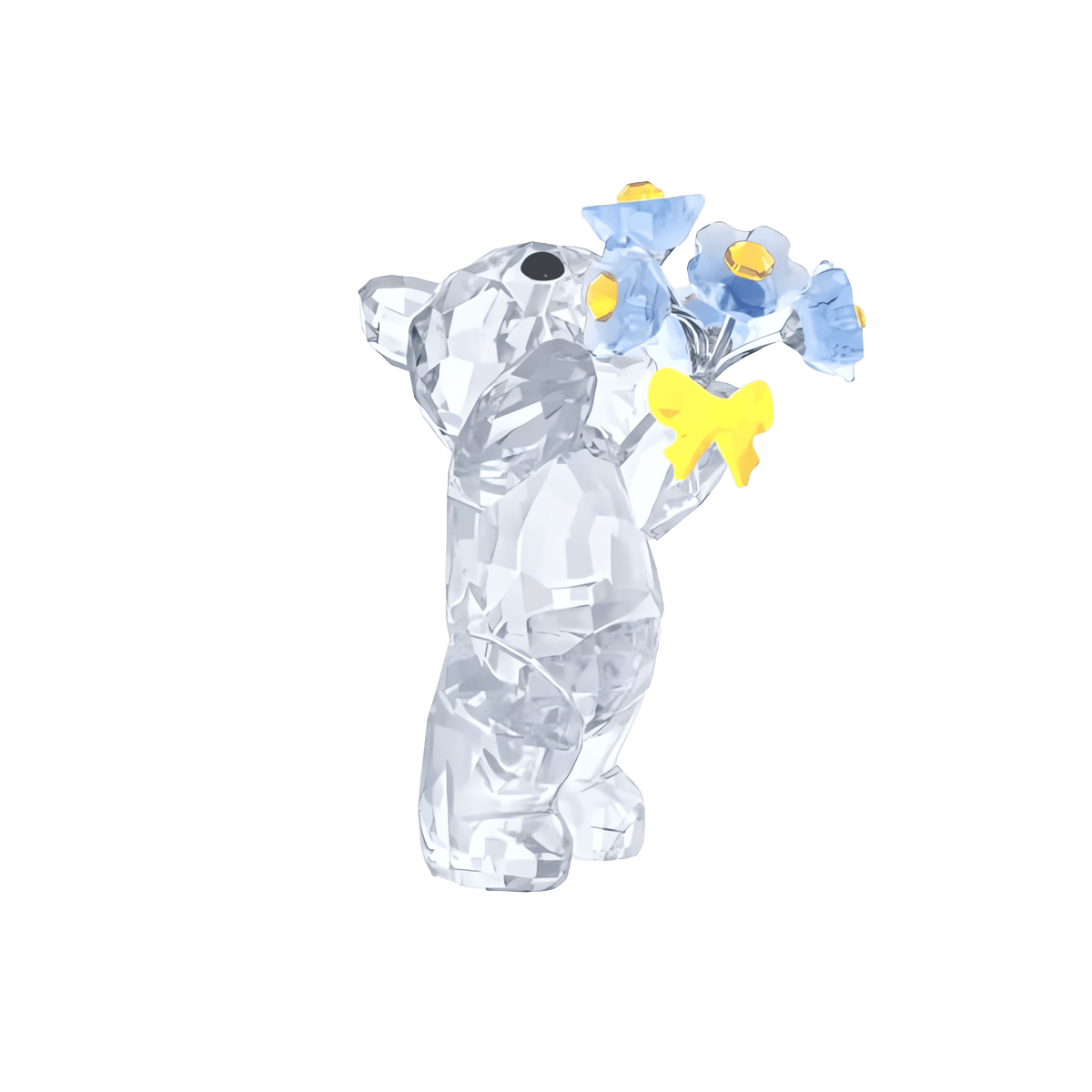 The Swarovski Kris Bear - Forget-me-not by Swarovski is a clear crystal figurine shaped like a bear, holding a bouquet of blue forget-me-not flowers with yellow centers tied with a yellow ribbon, set against a plain white background.
