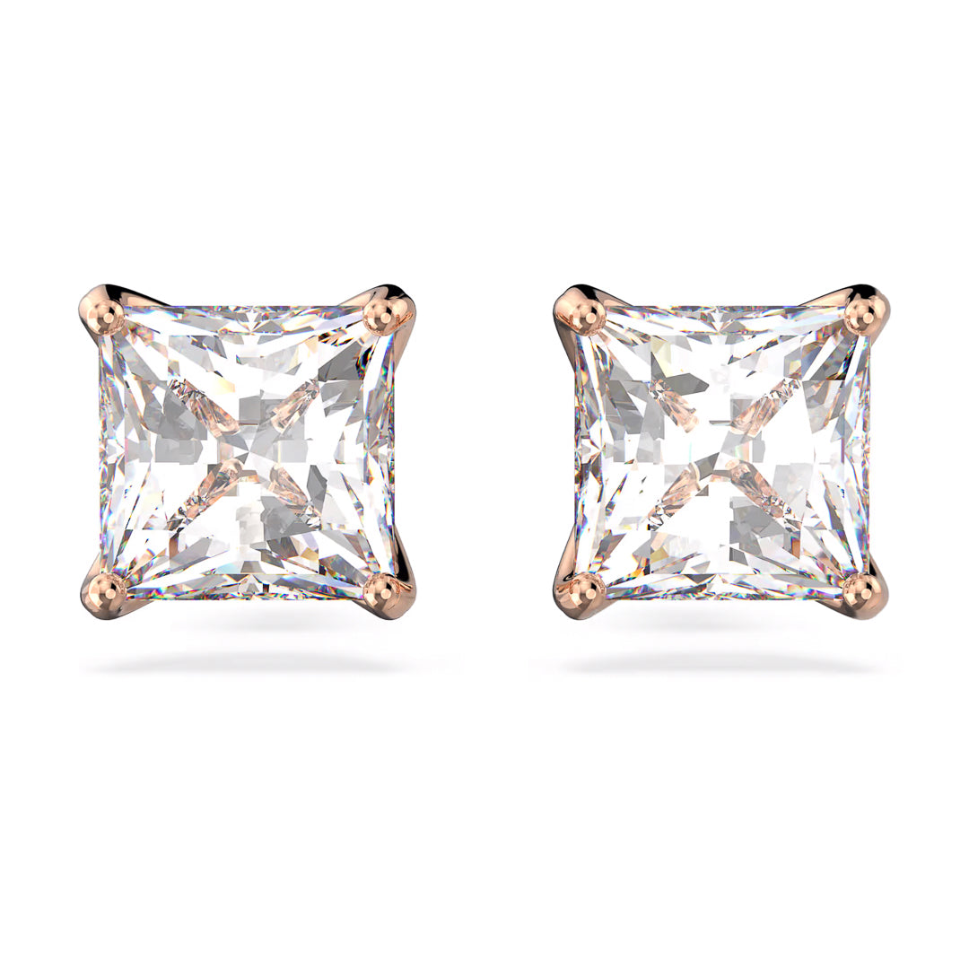 Swarovski Stilla Attract Stud Earrings by Swarovski feature a stunning pair of princess-cut stones with a sparkling surface, set in an elegant four-prong rose gold setting. The stones exhibit a brilliant and clear appearance, reflecting light beautifully for a dazzling effect and offering a timeless unisex aesthetic.