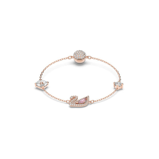 The Swarovski Rose Gold Dazzling Swan Bracelet features a delicate rose gold-plated design adorned with a Swarovski crystal-encrusted swan charm, accompanied by star and diamond-shaped crystals and a sphere of small crystals on a fine chain.