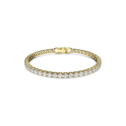 The Swarovski Round Cut Tennis Deluxe Bracelet is a gold-tone plated piece adorned with a series of dazzling oval-cut diamonds set in an unbroken line. The bracelet, crafted by Swarovski, features a secure clasp and is displayed flat against a plain white background.