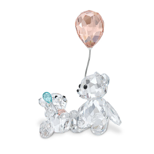 Swarovski My Little Kris Bear Mother & Baby Home Décor set includes two crystal teddy bears: the larger Kris Bear is holding a pink balloon, while the baby bear holds a blue one. Crafted from clear faceted glass, these figures exude a sparkling charm.