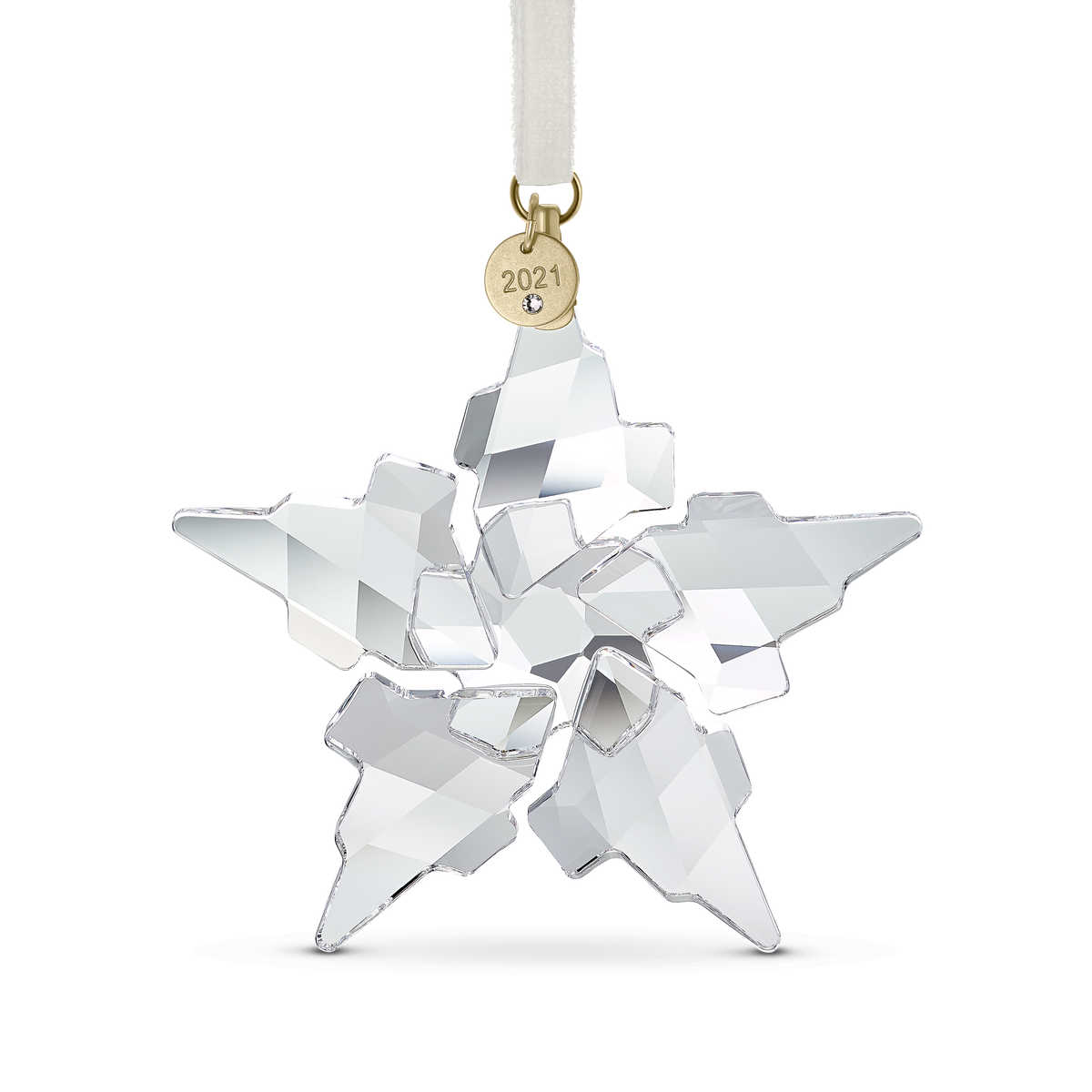 The Swarovski Annual Edition 2021 Ornament, a faceted crystal snowflake with five pointed arms, hangs from a white ribbon adorned with a gold tag engraved “2021.” Available at Raffi Jewellers and Swarovski Canada, this ornament by Swarovski beautifully reflects light with its clear and silvery surfaces.