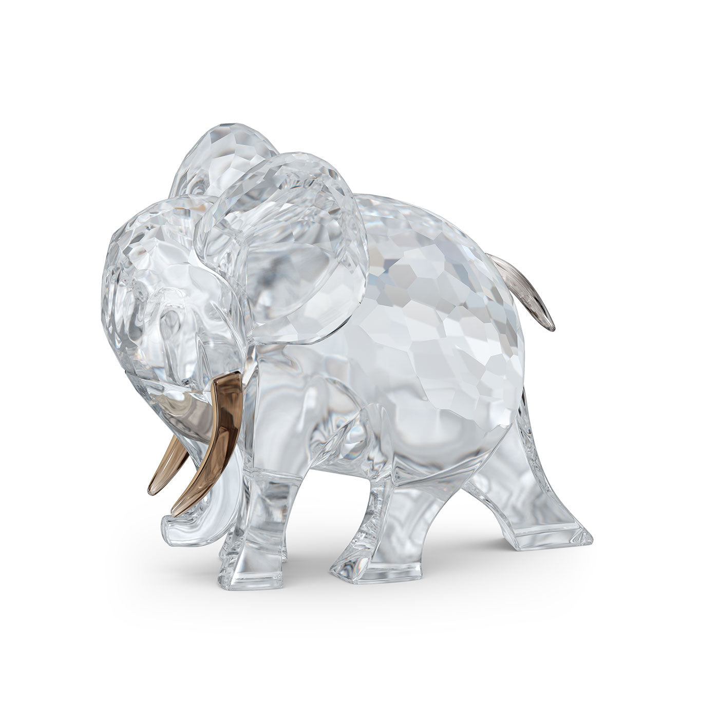 Presenting the Swarovski African Sunset Elephant Hami Home Décor, a stunning faceted crystal figurine by Swarovski. This exclusive piece from their collection showcases an elephant with prominent ears and golden tusks. Made from transparent material, it captures and reflects light beautifully, akin to an enchanting African sunset, giving it a mesmerizing sparkle.