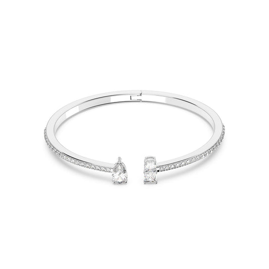 The Swarovski Mixed Cuts Attract Cuffs feature a sleek, timeless design with small pavé stones that sparkle along the surface. Its ends are adorned with a pear-shaped stone and a rectangular stone, exuding an elegant and sophisticated appearance typical of Swarovski's craftsmanship.