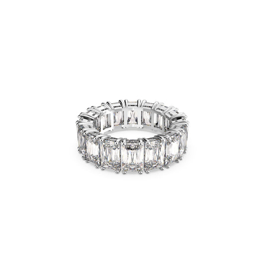 The Swarovski Vittore Rectangular Cut Ring, a silver eternity band from Swarovski, features sparkling stones with rectangular clear gemstones arranged in a continuous row. Set against a white background, the brilliant-cut stones are placed closely together, reflecting light beautifully and offering an elegant stacking look to the ring.