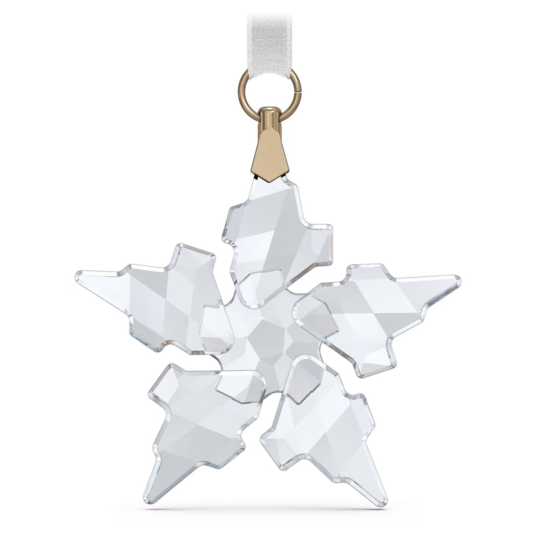 The Swarovski Little Star Ornament Home Décor showcases a geometric design and hangs elegantly from a white ribbon with a gold-toned metal clasp. Its clear crystal facets beautifully reflect light, producing a dazzling sparkling effect.