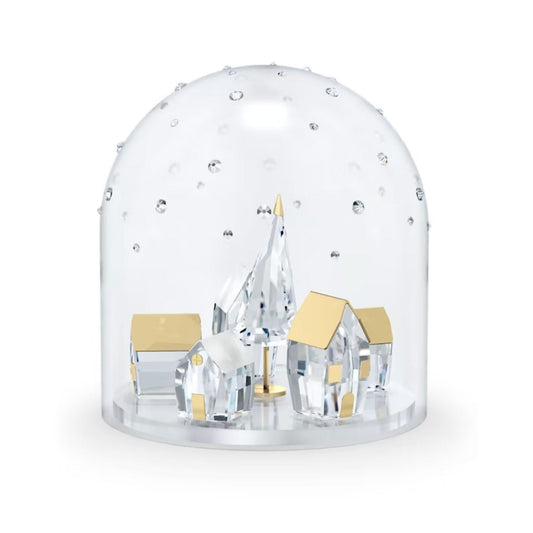 The Swarovski Holiday Magic Winter Village Bell Jar Home Décor features a bell jar design that houses a miniature winter village. It includes clear crystal houses, a faceted tree, and tiny crystals mimicking snow. The gold-toned roofs of the houses provide contrast and elegance to this enchanting scene.