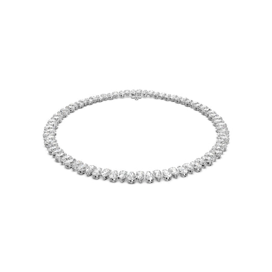 A Swarovski Pear Cut Zirconia Millenia Necklace is showcased against a plain white backdrop. This necklace, from the renowned brand Swarovski, features rhodium plating and displays a series of evenly spaced, sparkling round zirconia stones encircling the entire strand, highlighting its elegant and luxurious design.