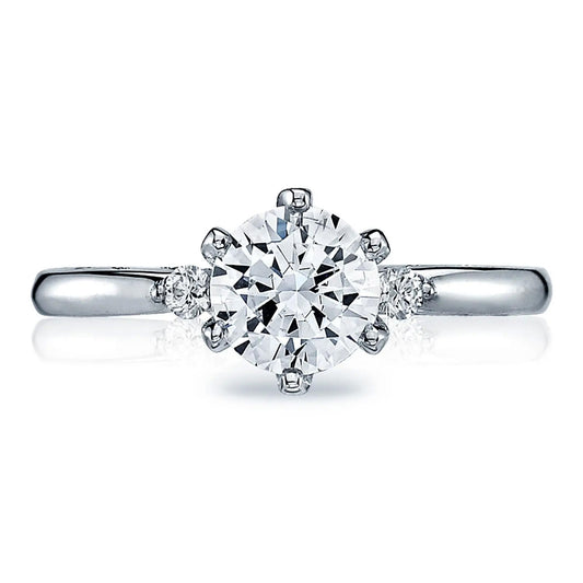 The Tacori Sculpted Crescent 18K White Gold Round Brilliant Three Stone Semi Mount with Diamond Side Stone Engagement Ring showcases exquisite craftsmanship, featuring a large round diamond at the center and two smaller diamonds on each side, all set on a smooth hand-engraved band.