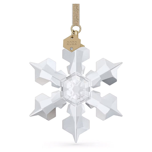 The Swarovski 2022 Annual Edition Ornament Home Décor, crafted by Swarovski, is a crystal snowflake ornament adorned with a gold tag inscribed “2022” and suspended from a gold ribbon. This exquisite piece showcases geometric facets and a central star shape that beautifully capture light, making it an ideal Christmas ornament for any festive setting.