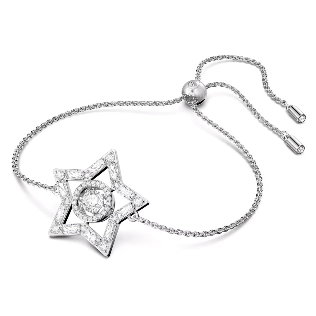 Introducing the Swarovski Stella Bracelet: a silver masterpiece featuring a six-pointed star with a circular dancing stone at its center. The delicate chain, adjustable with a sliding clasp, is adorned with smaller crystals that add sparkle, reminiscent of the twinkling beauty found in Austrian scenery.