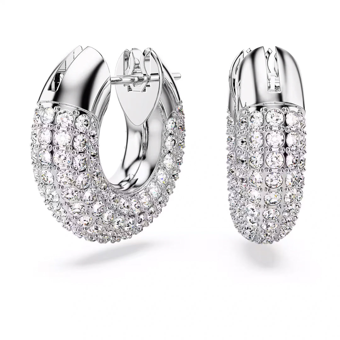 The Swarovski Dextera Hoop Earrings, from the renowned brand Swarovski, feature a polished silver finish adorned with multiple rows of dazzling clear crystals. Their rhodium-plated construction showcases a rounded, chunky design with a secure clasp at the top that brilliantly reflects light.