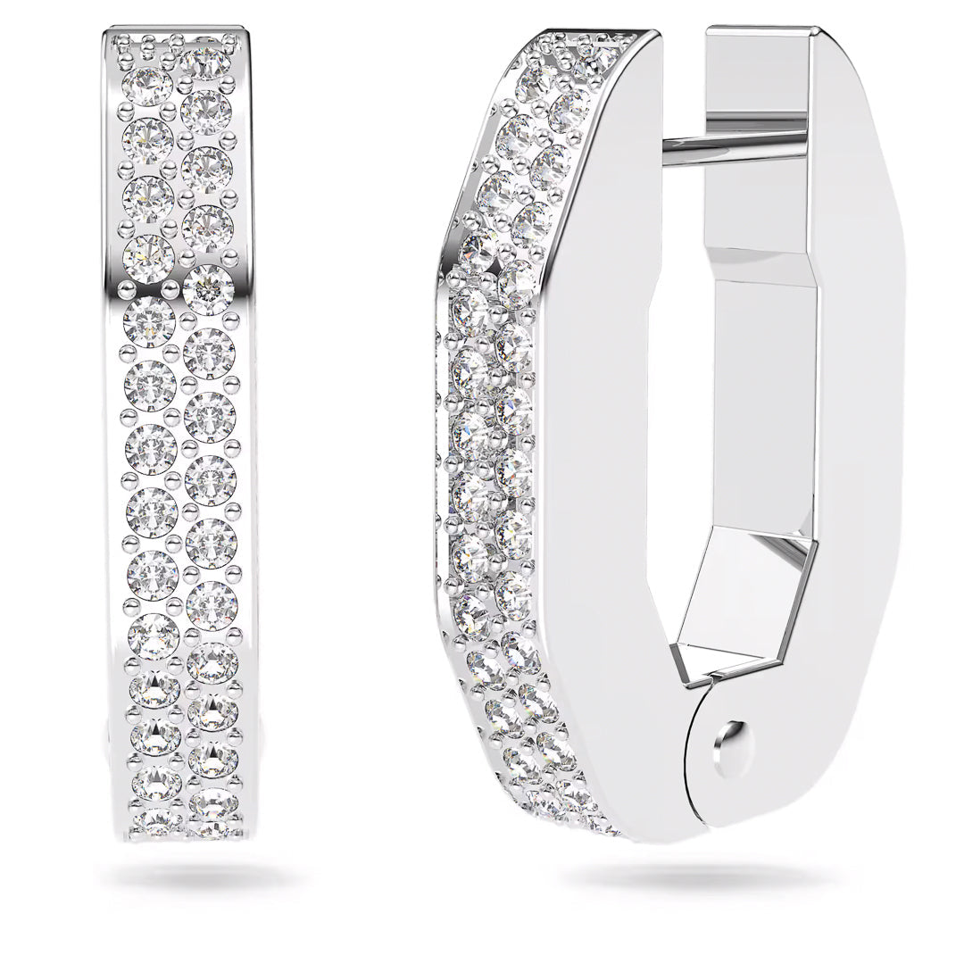 The Swarovski Dextera Hoop Earrings by Swarovski feature a pair of sleek silver hoops, each decorated with a row of sparkling crystals using the pavé technique. These earrings are crafted in a modern, geometric shape, blending elegance with contemporary style.