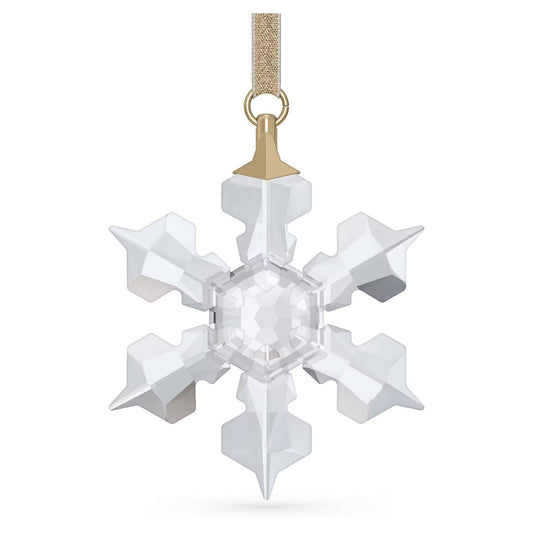 The Swarovski Little Snowflake Ornament Home Décor, featuring crystal facets and six shimmering points, hangs elegantly from a gold ribbon. Its clear, geometric design captures and reflects light, creating a dazzling sparkle.