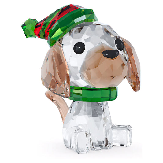 The Swarovski Holiday Cheers Beagle Home Décor is an exquisitely crafted crystal figurine featuring a beagle with a green and red festive collar. Its clear, shiny body accented with brown-tinted ears and complemented by black eyes and nose creates an adorable expression. This piece, from the renowned brand Swarovski, makes an ideal holiday decoration with its faceted design.