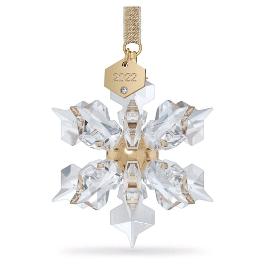 The Swarovski 2022 Annual Edition Ornament Home Décor boasts a magnificent crystal snowflake with a gold center, paired with a charming gold tag engraved with "2022," gracefully hanging from a glittering ribbon.