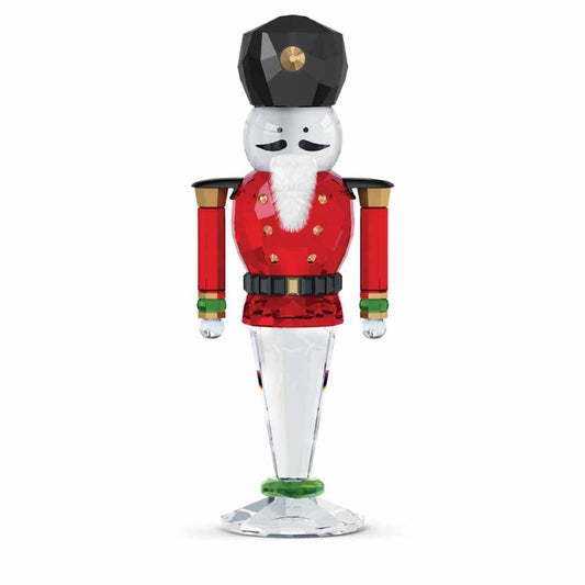 The Swarovski Holiday Cheers Nutcracker Home Décor piece, created by the renowned brand Swarovski, showcases a festive design featuring full-cut crystal craftsmanship. It highlights a striking black hat, white beard, and red uniform with elegant gold accents while standing firmly on a clear, round base.