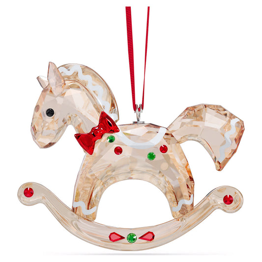 Introducing the Swarovski Holiday Cheers Gingerbread Rocking Horse Ornament—a clear glass masterpiece adorned with a red bow tie and colorful accents. This elegant home décor piece hangs gracefully by a red ribbon, featuring vibrant green and red decorative elements on its body and rocker base.